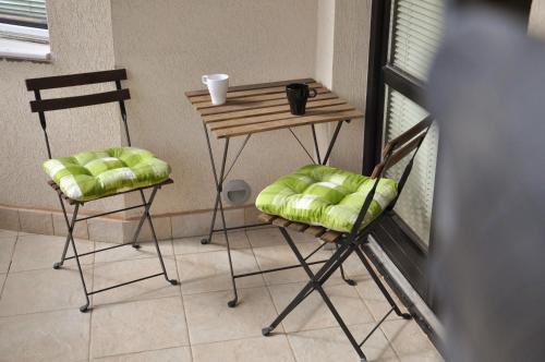 una mesa con dos sillas y una mesa con una taza. en Apartmani Vidic, en Zlatibor
