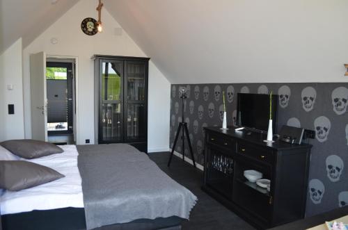 um quarto com uma cama e uma televisão de ecrã plano em Black Pearl em Büsum