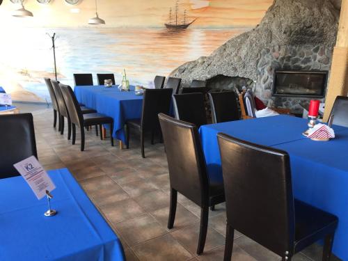 a row of blue tables and chairs in a restaurant at Hotel Szarlota - Kompleksowo na Kaszubach in Kościerzyna