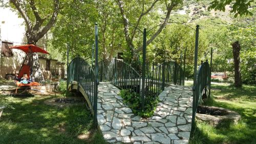 a person sitting under an umbrella next to a fence at Hani Zemenou in Arachova