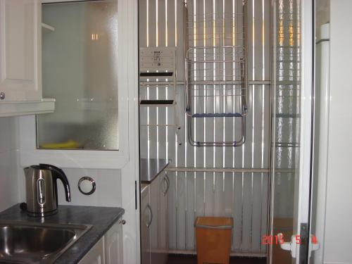 cocina con fregadero y nevera en Apartamento Sol- Fanals, en Lloret de Mar