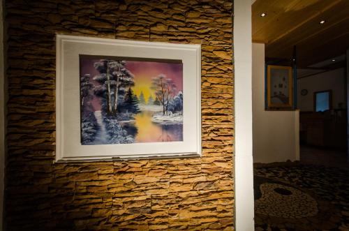 a painting hanging on a stone wall at Alpengasthof Grimmingblick in Planneralm