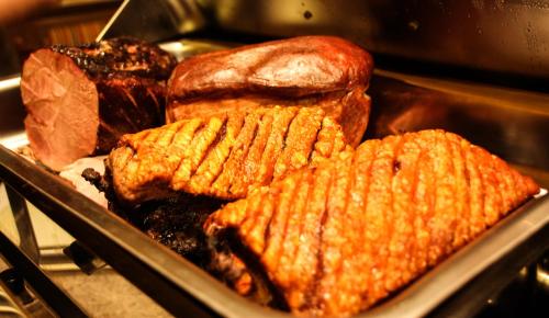 a pan filled with different types of meat and corn at Alpengasthof Grimmingblick in Planneralm