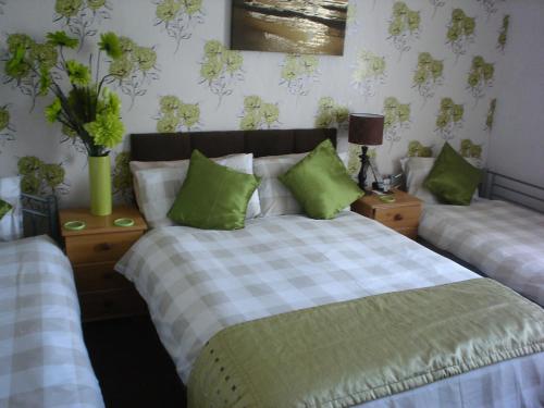 a bedroom with two beds with green pillows at The Franklyn Hotel B&B in Blackpool