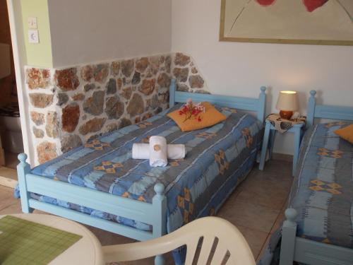 a bedroom with a blue bed with a stuffed animal on it at Fotini Studios in Emborios Kalymnos