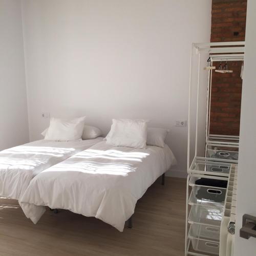 a bed with white sheets and pillows in a room at La Casa de las Tias in Villanueva de Córdoba