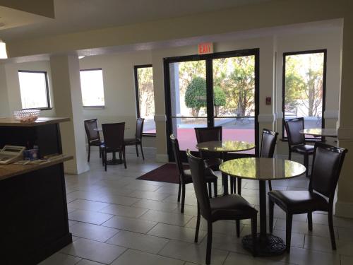 a dining room with tables and chairs and windows at Super 8 by Wyndham Dandridge in Dandridge