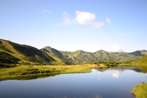 a view of a lake with mountains in the background at Alpengasthof Grimmingblick in Planneralm