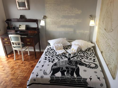 a bed with a black and white blanket with an elephant on it at Casino & Beach Apartment in Figueira da Foz