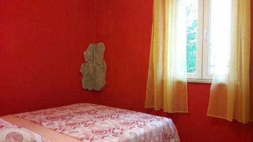 ein rotes Zimmer mit einem Bett und einem Fenster in der Unterkunft Holiday Home Dida Blaž in Trogir