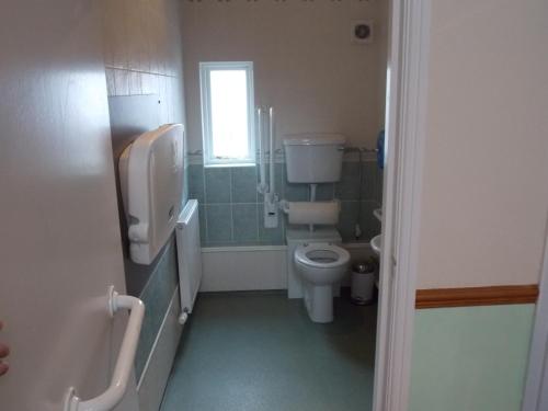 a bathroom with a toilet and a window at Cross Keys Hotel in Canonbie