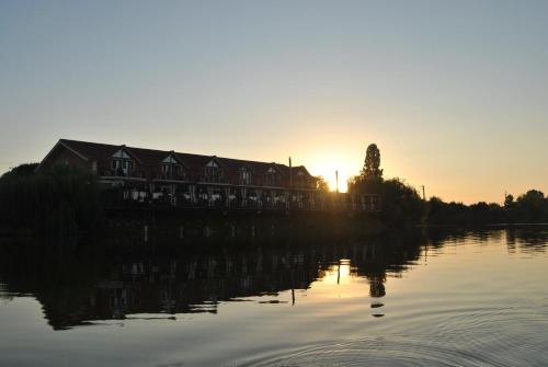 a house on the shore of a lake at sunset at Lacul Racilor in Olimp