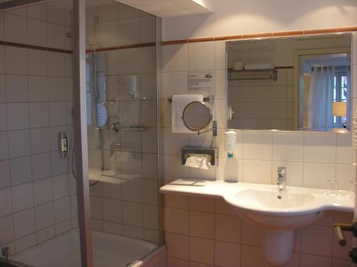 a bathroom with a sink and a shower at Hotel am Doktorplatz in Rheda-Wiedenbrück