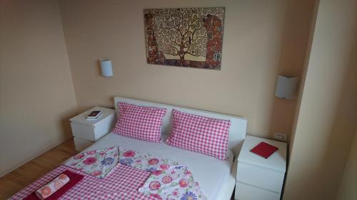 a small bedroom with a bed with pink and white pillows at Apartment Vladka Koper in Koper