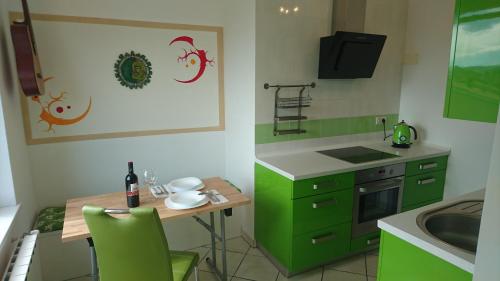 a kitchen with green cabinets and a table and a sink at Apartment Vladka Koper in Koper