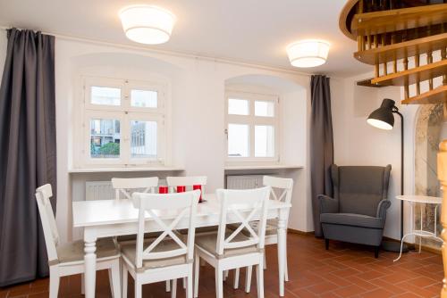ein Esszimmer mit einem weißen Tisch und Stühlen in der Unterkunft KulturQuartier in Regensburg