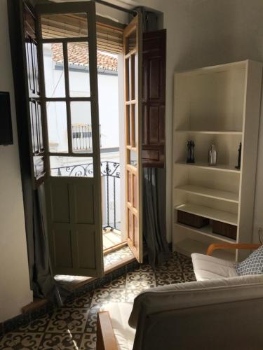 una sala de estar con una puerta que da a un balcón en No 31 Bed & Breakfast, en Olvera