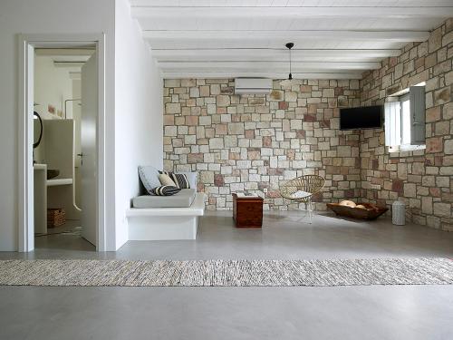 a living room with a brick wall and a couch at Studio Vipera in Triovasálos