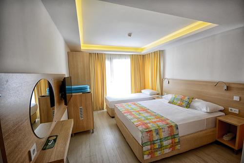 a hotel room with two beds and a television at City Hotel Marmaris in Marmaris