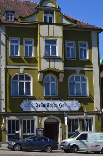 un bâtiment avec des voitures garées devant lui dans l'établissement Hotel Fränkischer Hof, à Kitzingen