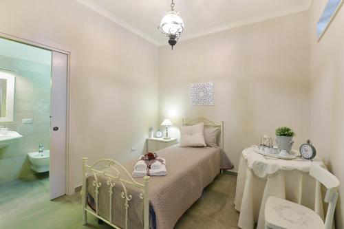 マンドゥーリアにあるB&B A Casa di Nonna Giovannaのベッドルーム1室(ベッド1台、テーブル、シンク付)