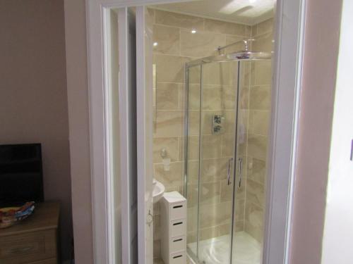 a shower with a glass door in a bathroom at Adelphi Villa in Oban