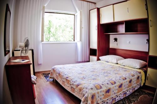 a small bedroom with a bed and a window at Apartments Slijepcevic in Hvar