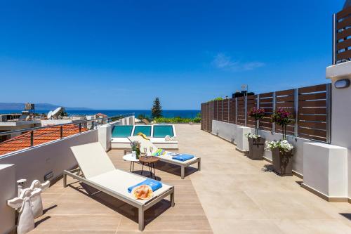 a balcony with chairs and a table on a building at Angels Suites in Plataniás
