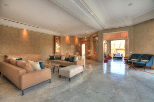 a large living room with couches and tables and chairs at Palais d'hôtes Darsor in Marrakech