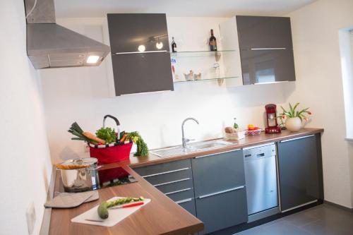 a kitchen with gray cabinets and a wooden counter top at Dein Hyggelig-Haus in Elz