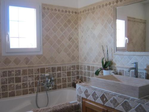 une salle de bain avec une baignoire et un lavabo dans l'établissement Mas provençal, à Poussan