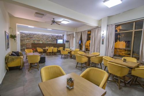 a dining room with tables and yellow chairs at Idillion in Vília
