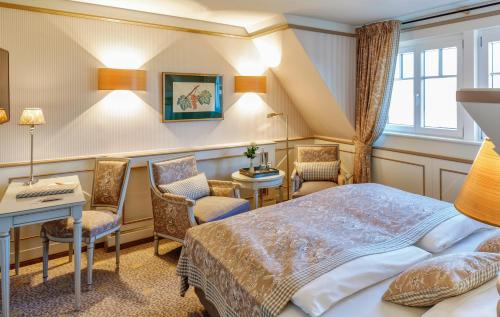 a hotel room with a bed and a desk and chairs at Landhotel Restaurant zur Krone in Gottenheim