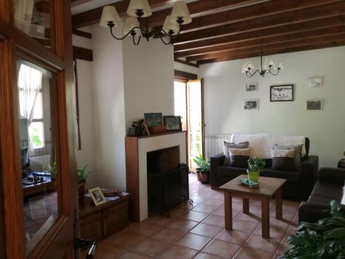 a living room with a couch and a fireplace at Casa Fidela in Lomeña