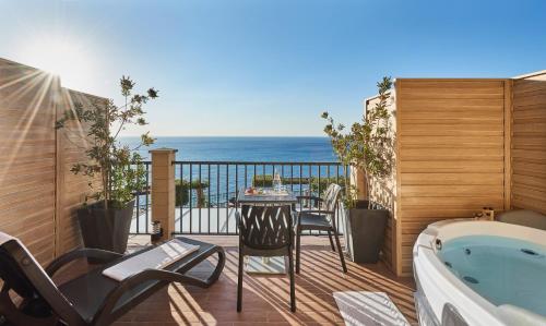 a balcony with a table and a bath tub at Hotel Rocca Della Sena in Tropea