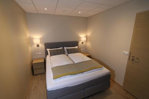 a large bed in a room with two lamps at K16Apartments in Akureyri