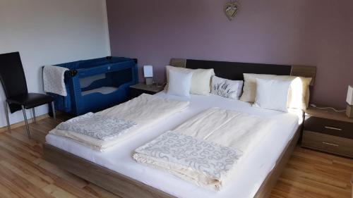 a bedroom with a large bed with white sheets at Ferienhaus Stricker in Ehrwald