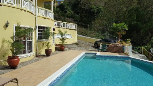 a swimming pool in front of a house at Heavenly Suites in La Feuillet