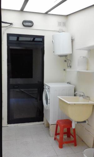 a bathroom with a sink and a washing machine at The April Maisonette in Marsaskala