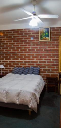 a bedroom with a brick wall and a bed at Divina Presencia in Cafayate