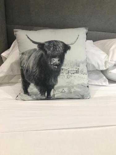 a black and white cow pillow on a bed at The Bulls Head in Swadlincote