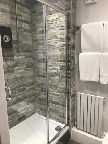 W łazience znajduje się prysznic ze szklanymi drzwiami. w obiekcie The Bulls Head w mieście Swadlincote