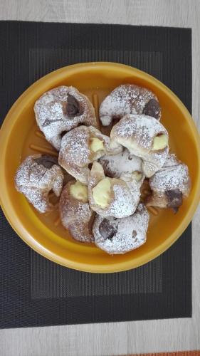 a yellow plate of powdered donuts on a table at Residenza Wagner in Palermo