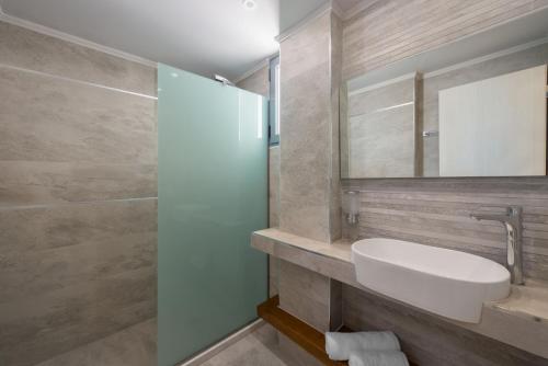 a bathroom with a sink and a mirror at Lardos Luxury Apartments in Lartos