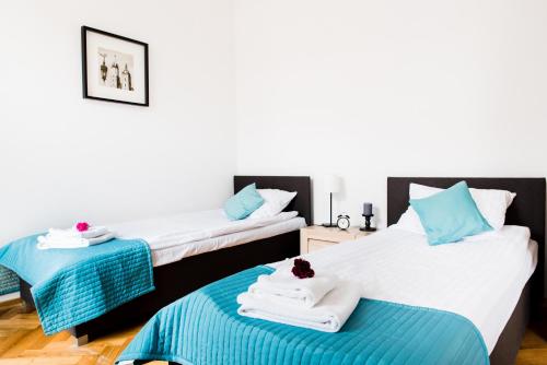 クラクフにある3D Royal Castle Apartamentのベッド2台(青と白のタオル付)