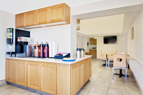 a kitchen with wooden cabinets and a counter top at Knights Inn Page in Page