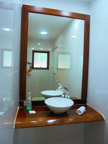 a bathroom with a sink and a large mirror at Pousada Náutilus in Ilhabela