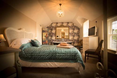 a bedroom with a bed and a dresser and a mirror at Brockley Hall Hotel in Saltburn-by-the-Sea