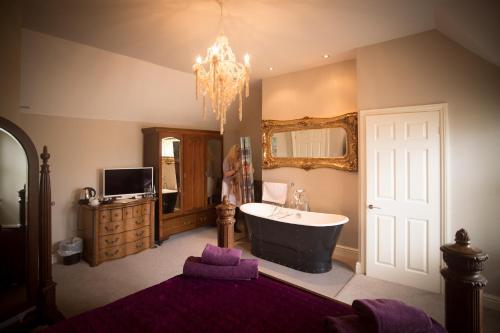 a bathroom with a tub and a sink and a mirror at Brockley Hall Hotel in Saltburn-by-the-Sea