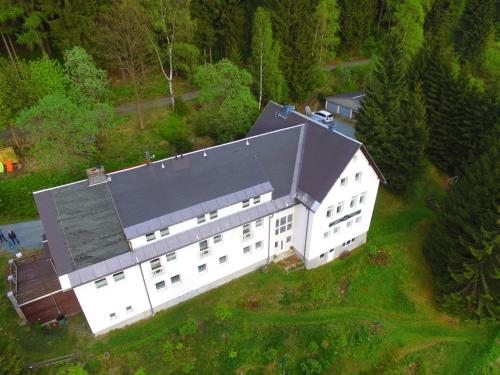 an overhead view of a large white building with a black roof at Greizer Kammhütte Gaststätte & Pension in Klingenthal